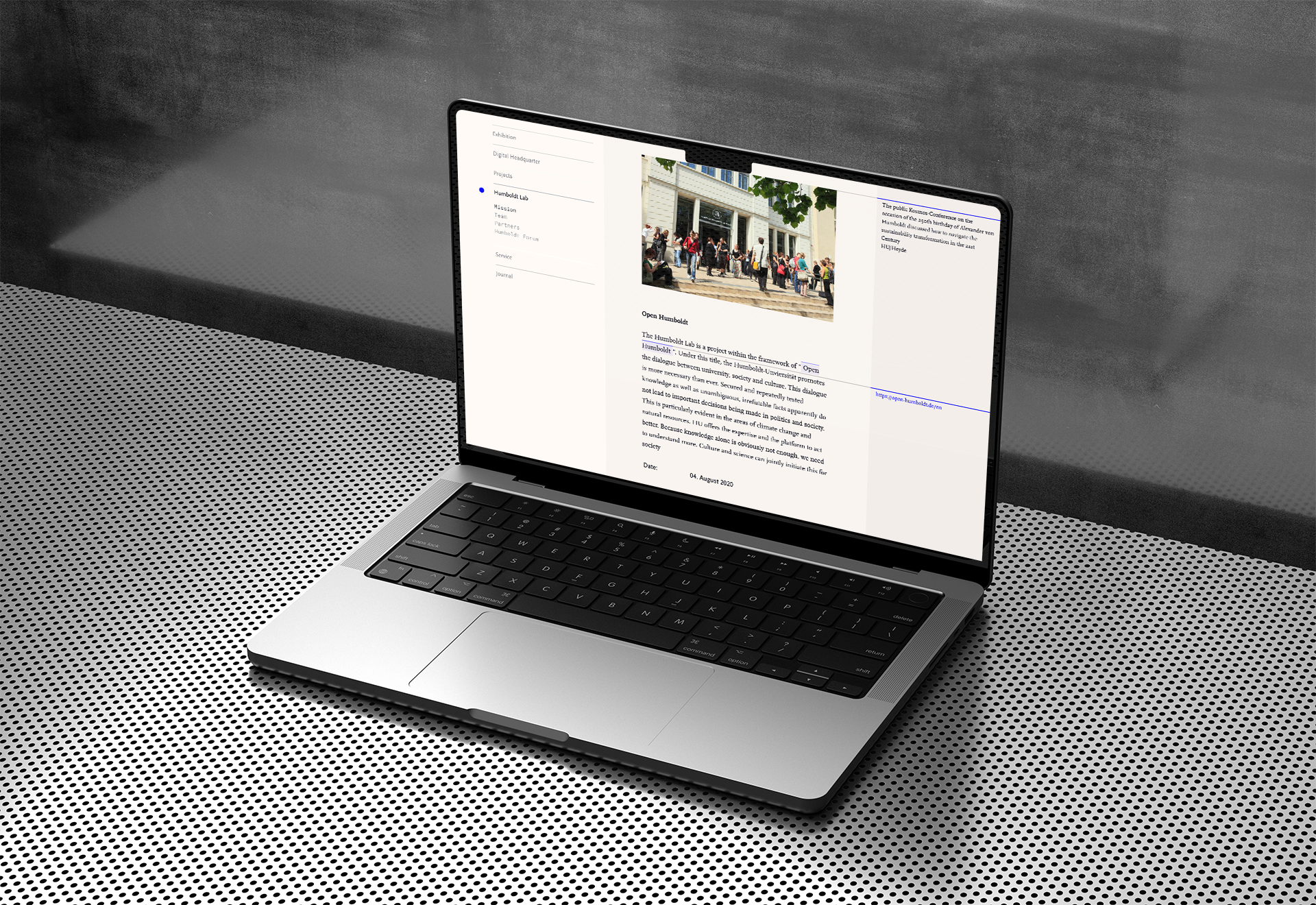 A mockup of a laptop in a cool metallic environment showing an article web page in a clean and elegant design. Menu on the left, text and images in the middle and a side bar with additional information.