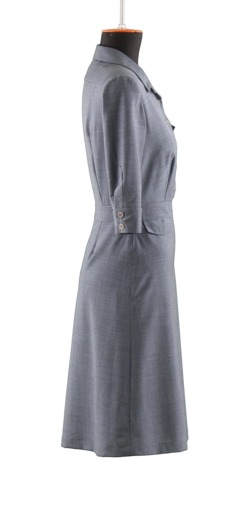 A simple grey, buttoned uniform dress belonging to the women collection with three quarter sleeves in side view on a headless mannequin with cutout background.
