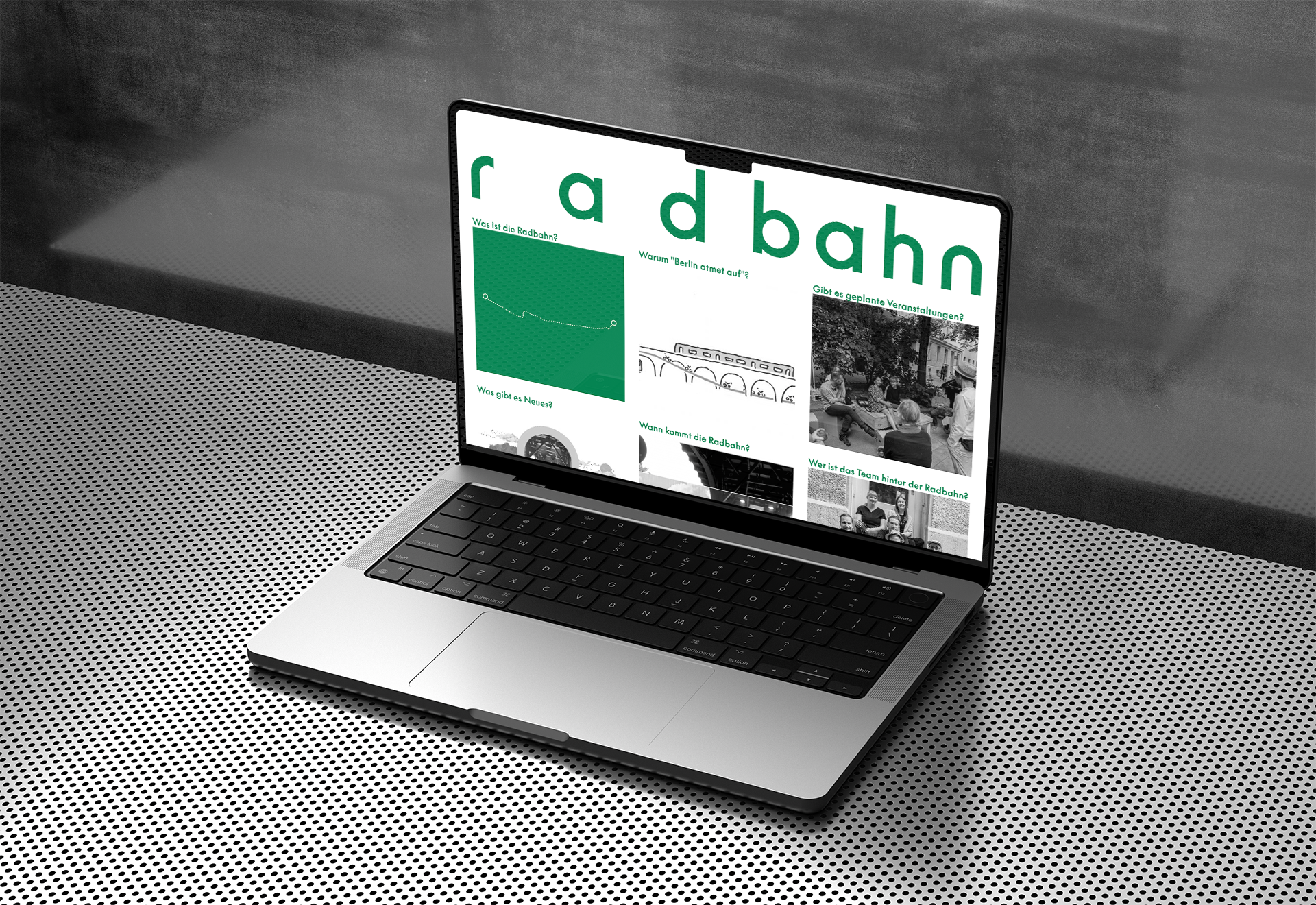 A mockup of a laptop on cool metallic surface showing a clean startpage with only a huge headline